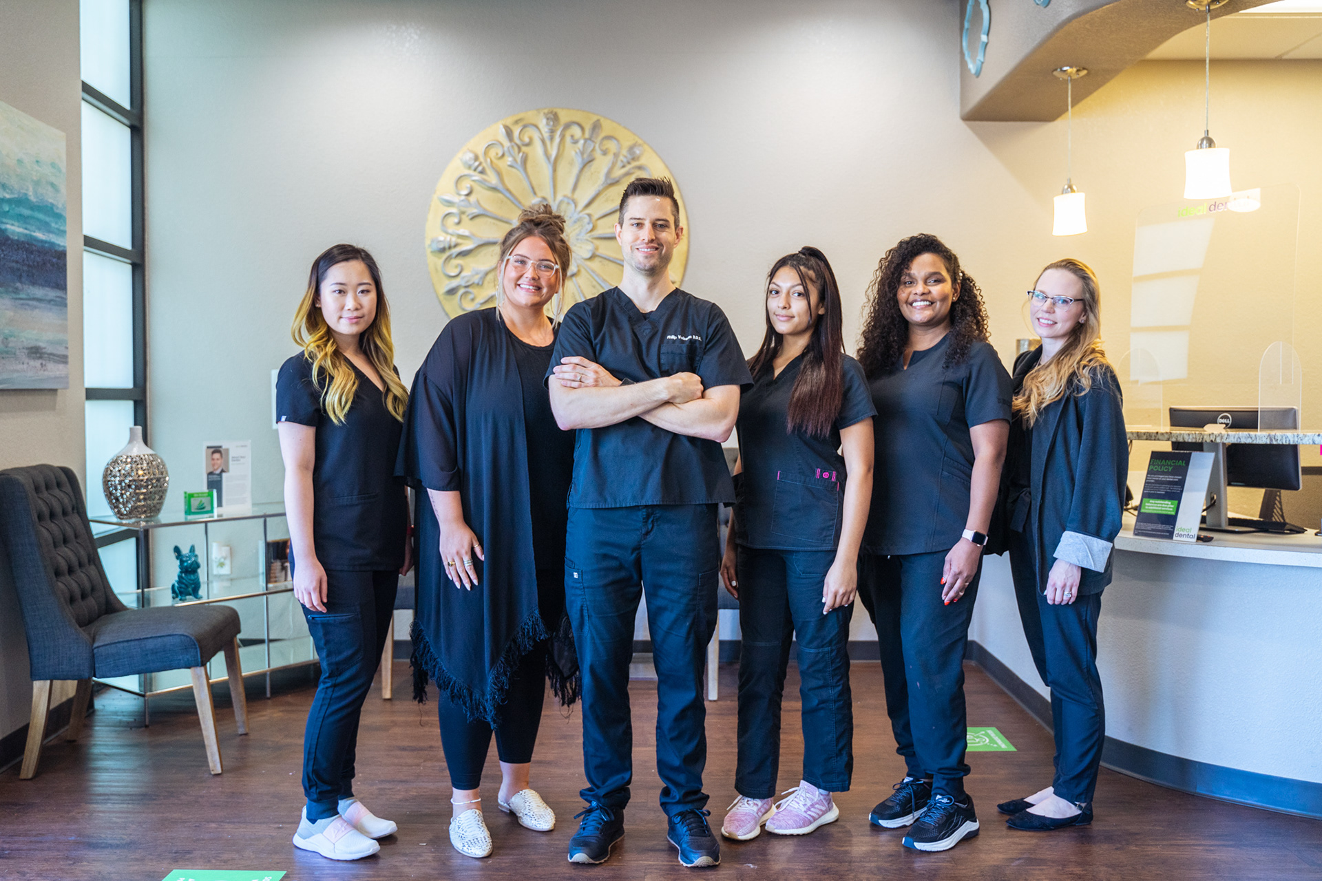 happy dental employees standing and smiling on the office waiting room