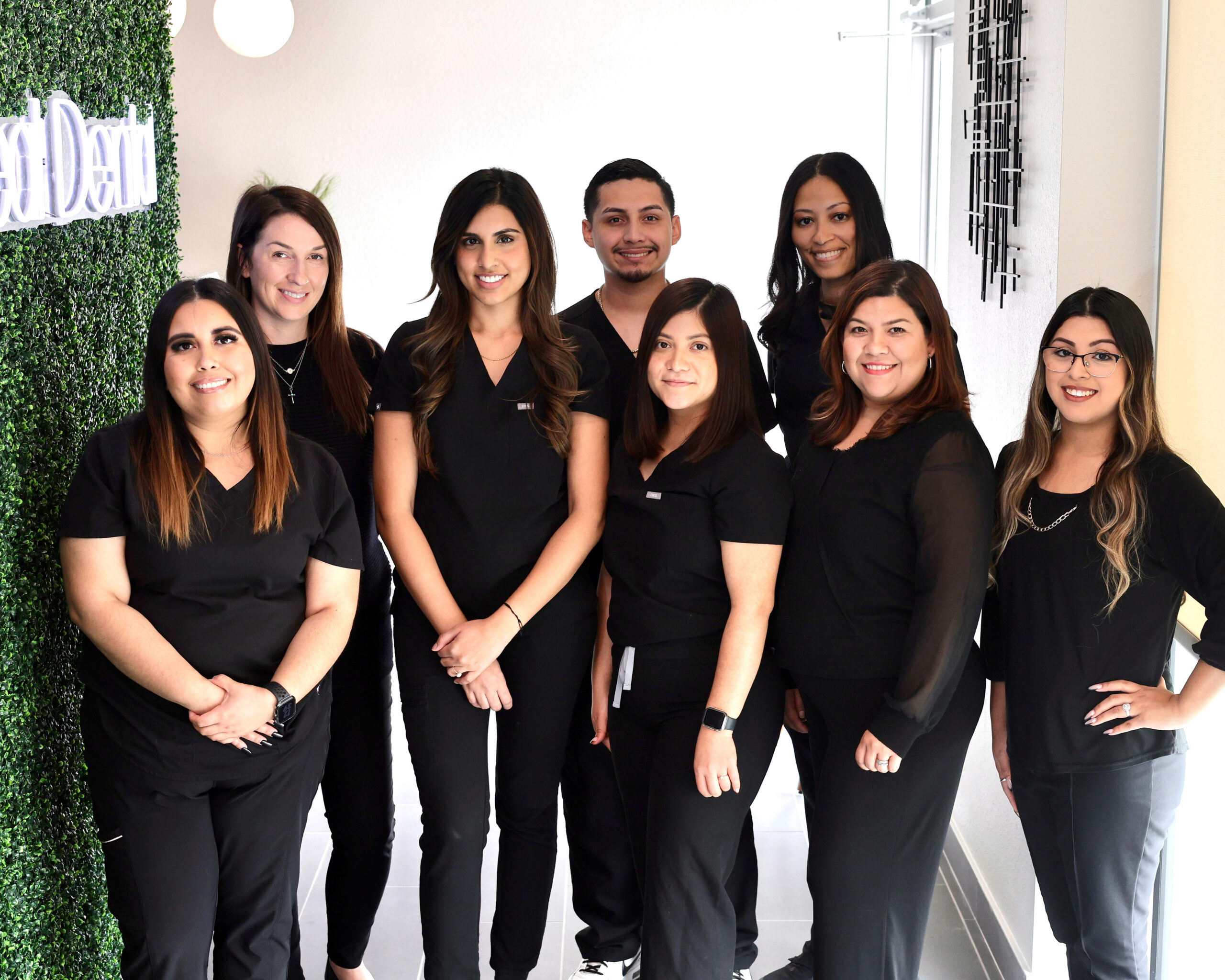 happy dental employees standing together in the office smiling